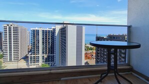 Ein Balkon mit Blick auf hohe Gebäude und ein Gewässer.