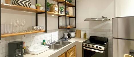 A modern kitchen with wooden cabinets, a stainless steel stove, and a built-in oven.