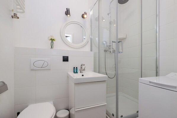 A modern bathroom with a toilet, sink, and shower.