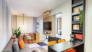 A modern living room with a sofa, dining table, and kitchen area. - Staybridge - Sophisticated space in Itaim Bibi (Itaim Bibi São Paulo)