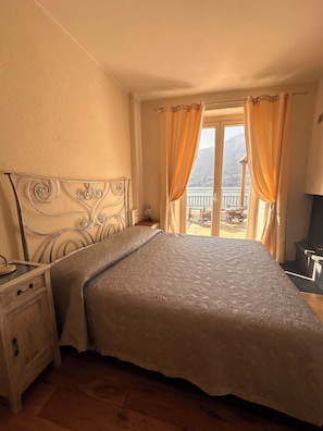 Une chambre à coucher avec un lit, une table de chevet et une vue sur l’extérieur.