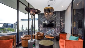 A modern living room with leather sofas, a round coffee table, and a fireplace.