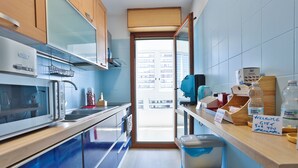 A modern kitchen with a microwave, sink, and wooden cabinets. - Naples Stay Inn - close to metro & all connections (Napoli)