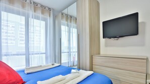 A hotel room with a bed, a television mounted on the wall, and a window with curtains. - Naples Stay Inn - close to metro & all connections (Napoli)