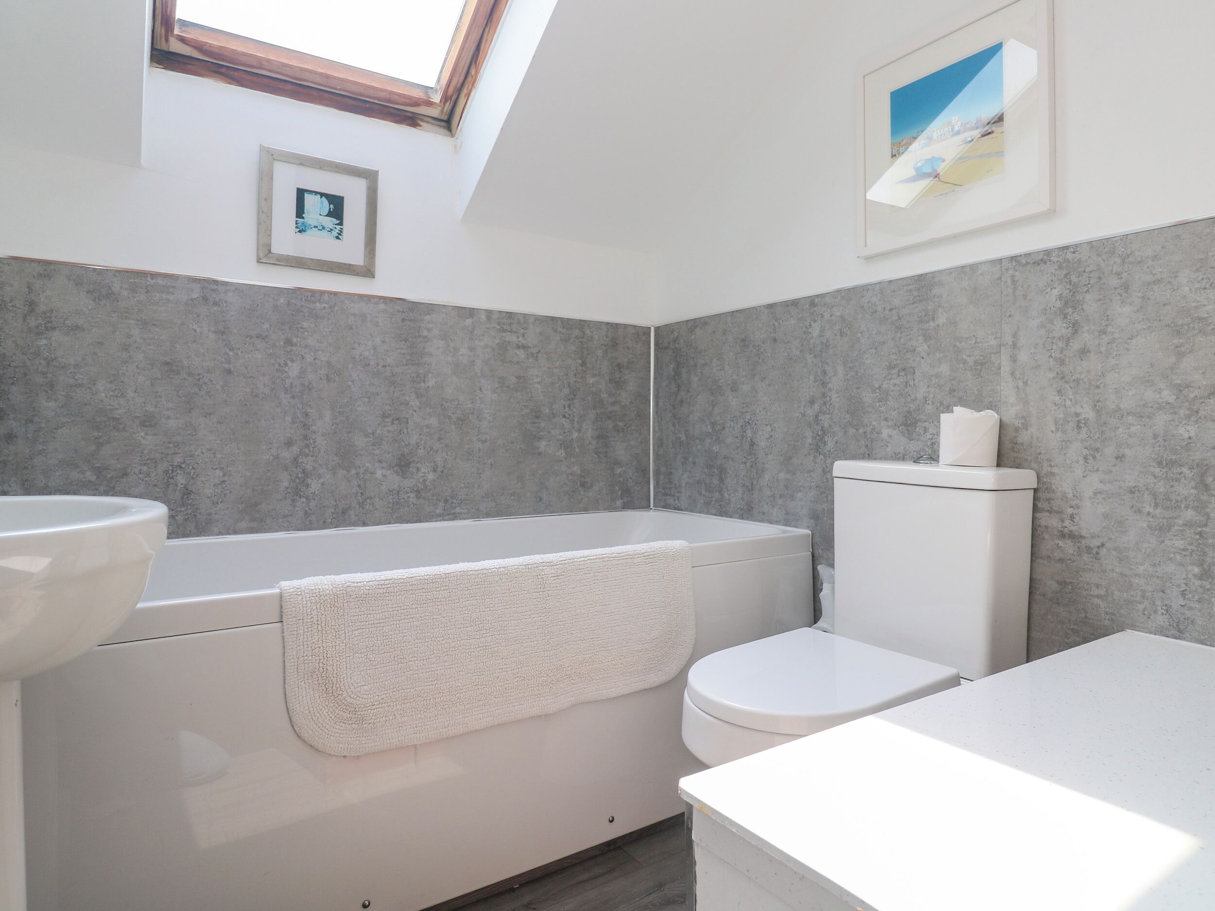 A modern bathroom with a bathtub, toilet, and sink.