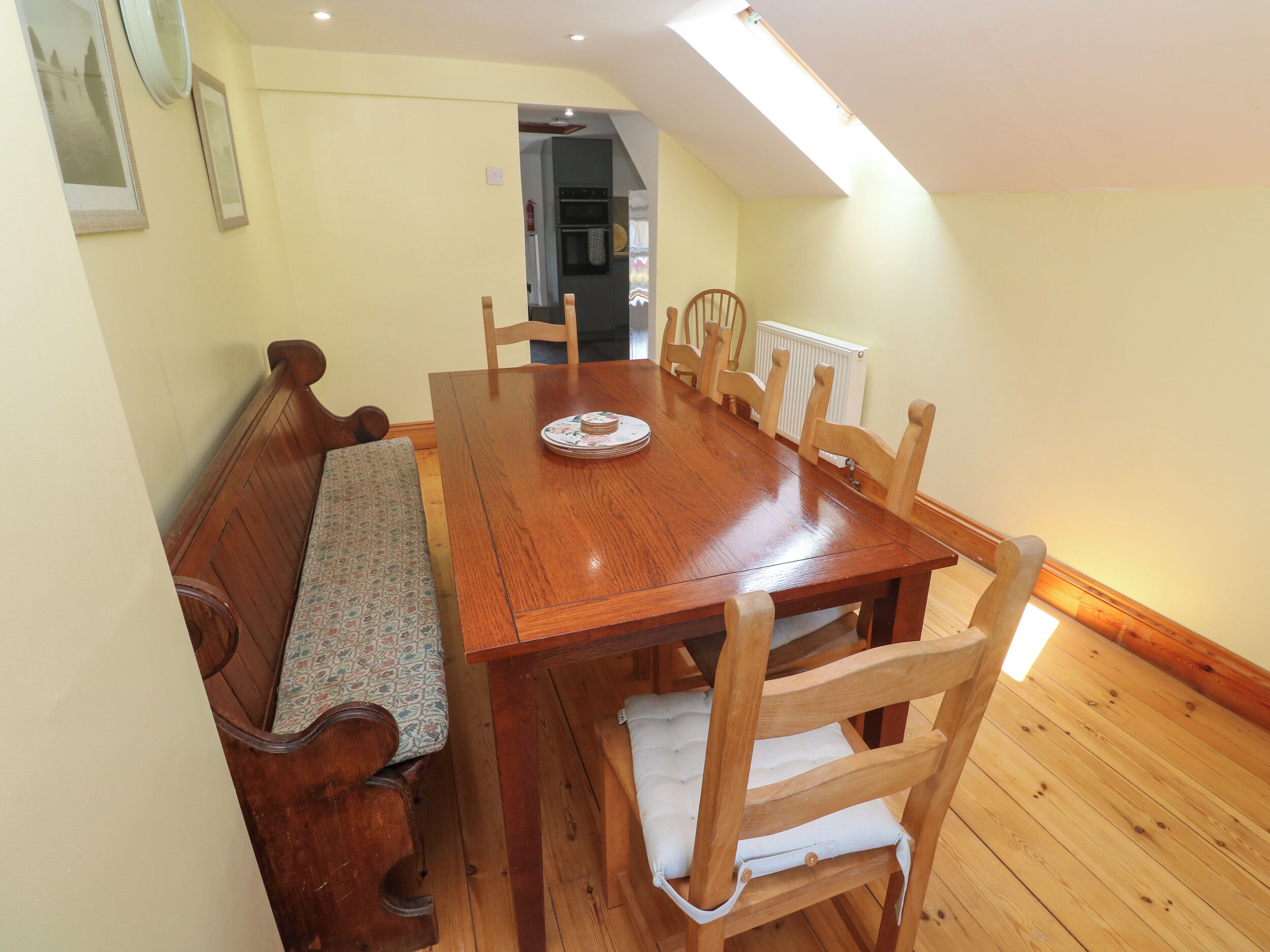 A dining area with a wooden table, benches, and chairs.