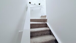 A staircase with carpeted steps leading to a white door.