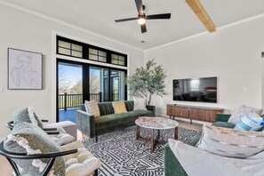 A living room with a sofa, armchair, coffee table, and a TV.