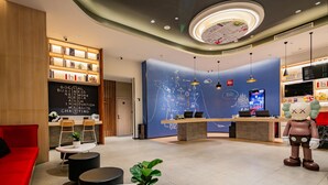 A modern hotel lobby with a reception desk, seating area, and a large decorative wall. - Ibis Chengdu Gaoxin Tianfu Software Park Hotel (Chengdu)