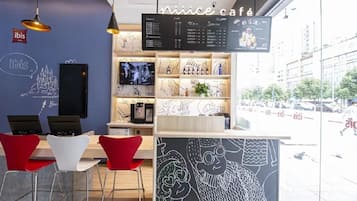 Interior moderno de café com um quadro de menu, área de estar e vista para a rua.