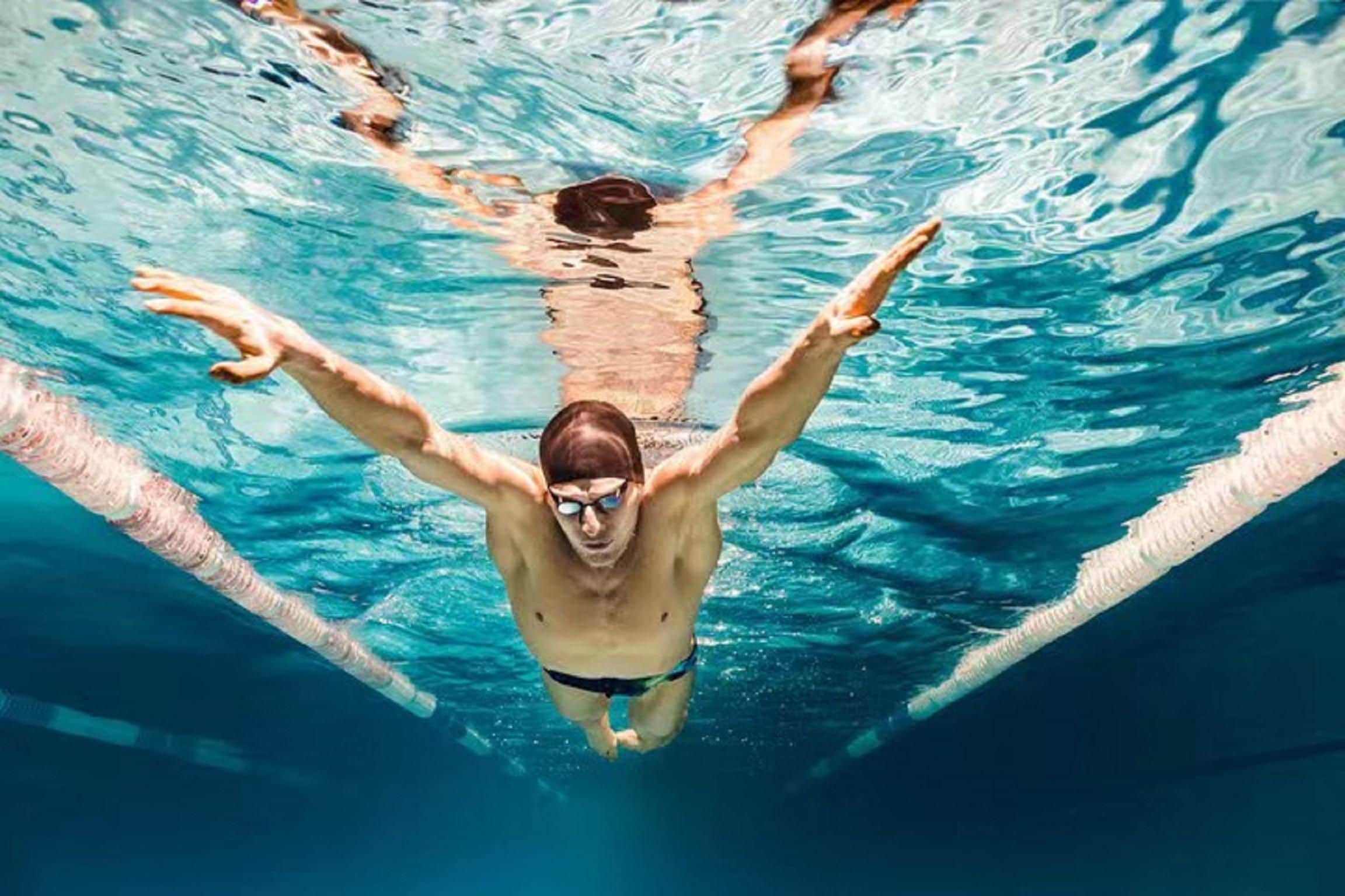 A swimmer in a pool with lane dividers.