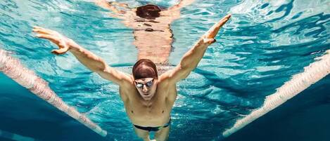 A swimmer in a pool with lane dividers.