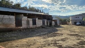 A series of rustic, weathered buildings with a dirt ground, likely used for storage or livestock. - Charming 3-bedroom scenic villa with a pool, WiFi in the lovely north (يبلا (إربد))