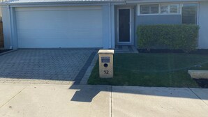 A single-story house with a garage door, a small front porch, and a mailbox labeled '52'. - Family friendly accommodation close to the beach. (Alkimos)