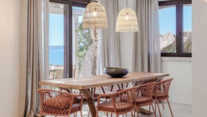 A dining area with a wooden table, wicker chairs, and a large bowl. - La Tiara di Cervo  (Arzachena)
