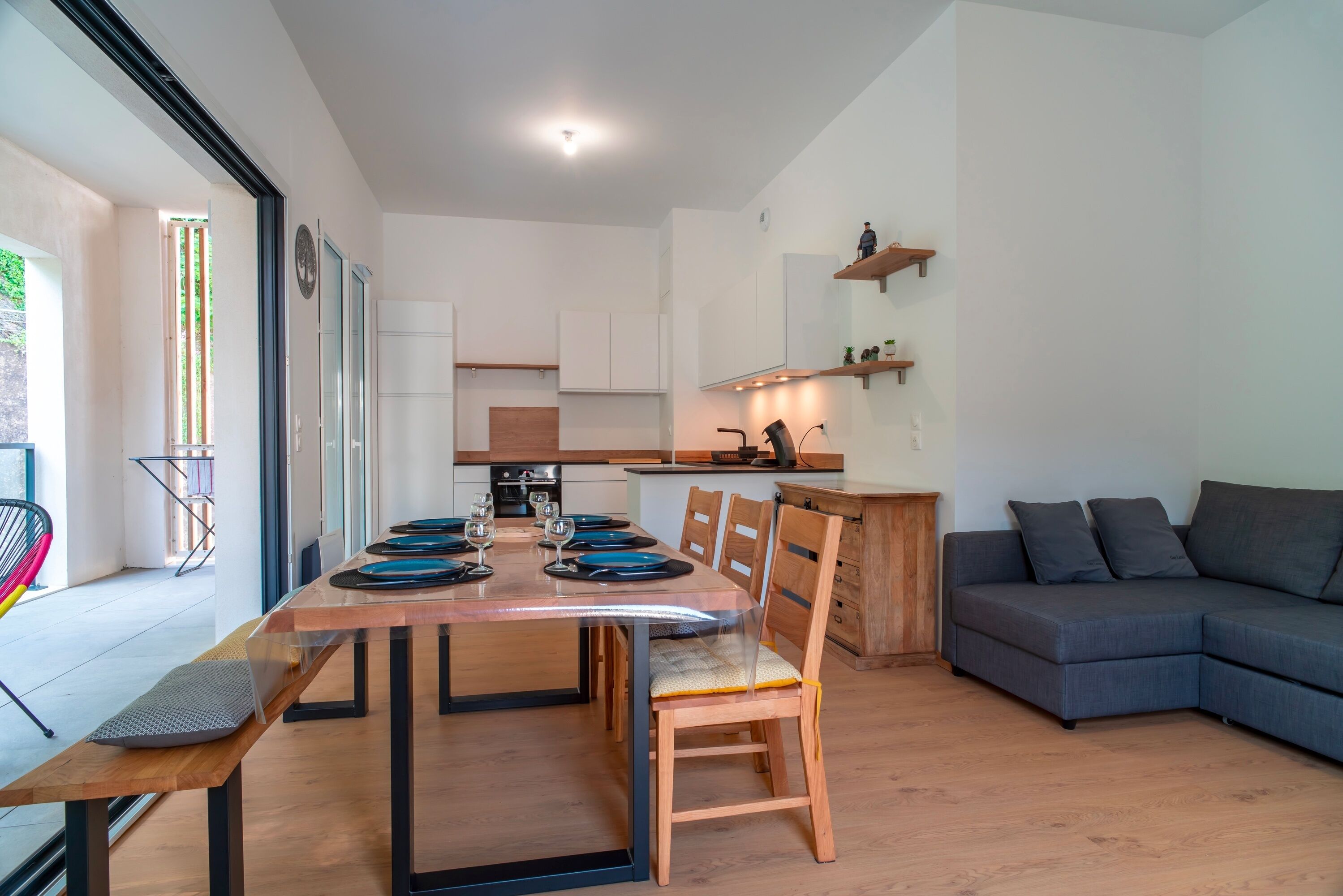A modern living space with a dining area, kitchen, and seating area.