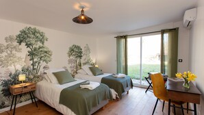 A bedroom with two beds, a desk, and a chair.