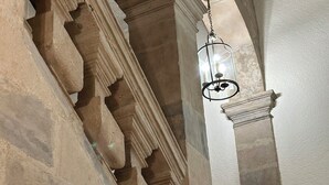 A stone staircase with a wooden handrail and a hanging light fixture. - The Charm of Anduze (Anduze)
