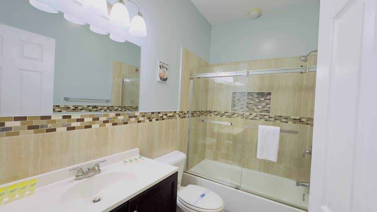 A bathroom with a shower, toilet, and sink.