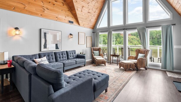 A spacious living room with a high ceiling, large windows, and a view of greenery outside. - Spacious 4BR Cabin in Doniphan – Perfect for Family Getaways (Doniphan)