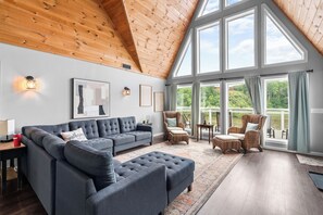 A spacious living room with a high ceiling, large windows, and a view of greenery outside. - Spacious 4BR Cabin in Doniphan – Perfect for Family Getaways (Doniphan)