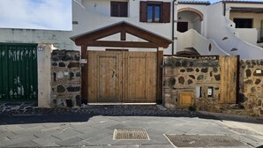 Een gebouw met stenen muren, een houten poort en een geplaveid voetpad.