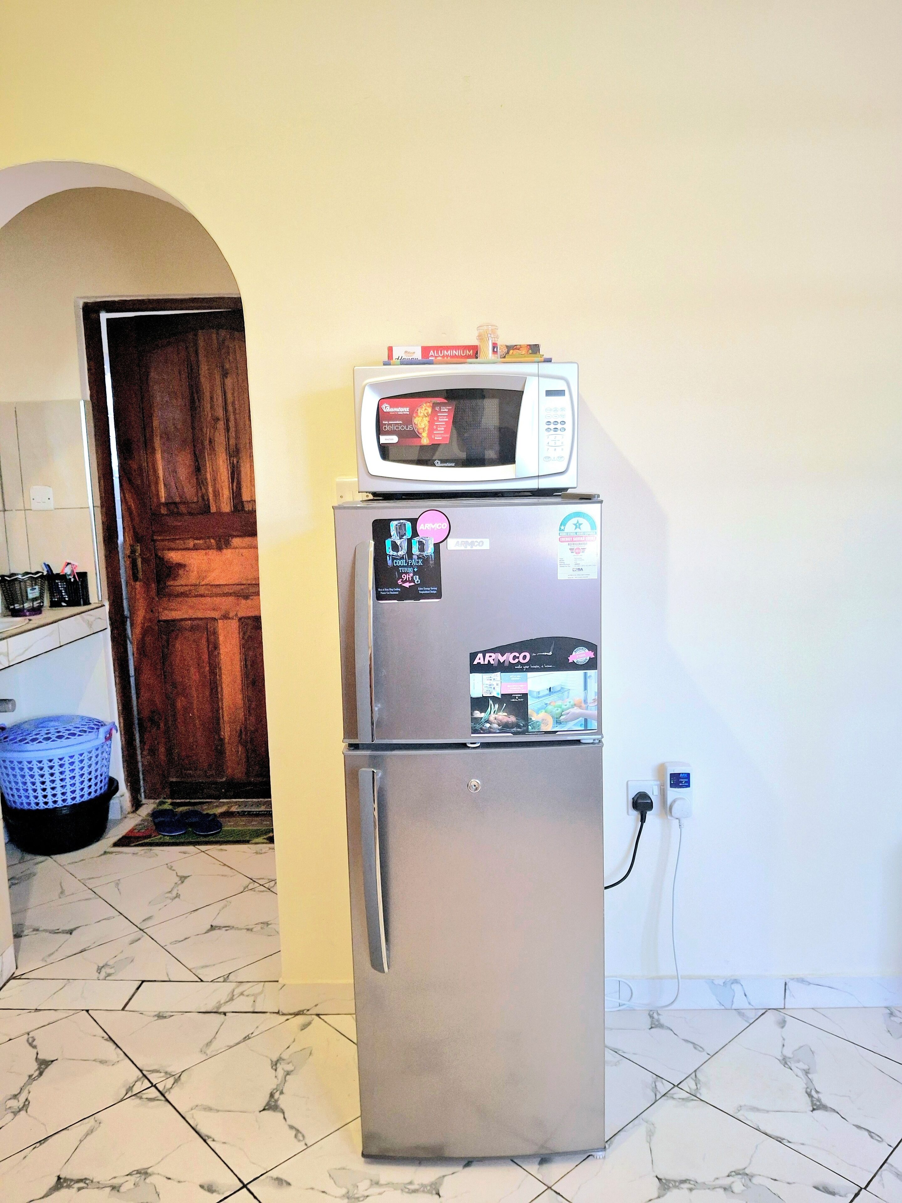 Une cuisine compacte équipée d’un réfrigérateur, d’un four à micro-ondes et d’un petit évier.