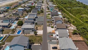 Une zone résidentielle côtière comprenant des maisons, une plage et une jetée.
