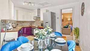 A modern kitchen with white cabinets, a tiled backsplash, and a central island. - The Bristol Harbourside Apartments - Sleeps 16 (Bristol)