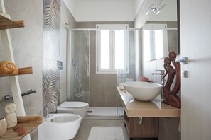 Een douche, een haardroger, een bidet, handdoeken