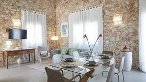 Un comedor con pared de piedra, televisor y sofá.