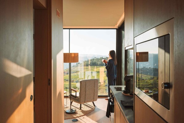 A room with a large window, a chair, a table, and a coffee machine. - Five Sabrosa Senses (Sabrosa)