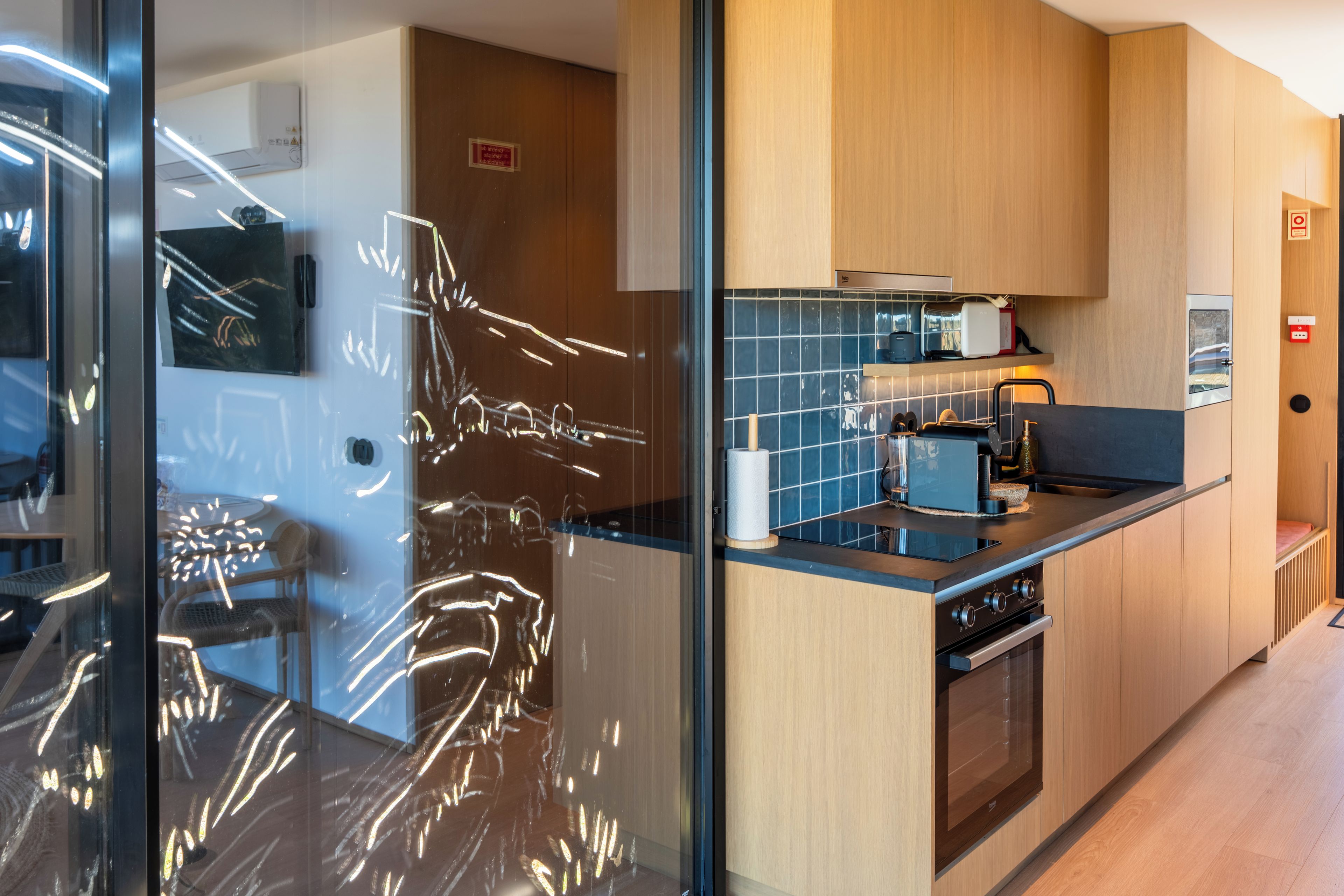 A modern kitchen with a black countertop, wooden cabinets, and a built-in oven.