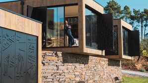 A modern house with a stone foundation, large windows, and a wooden exterior. - Five Sabrosa Senses (Sabrosa)