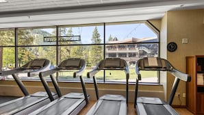 A gym with three treadmills, large windows with a view of a building and trees. - Everline Queen Studio w/ Forest Views # 723 (Olympic Valley)