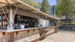 An outdoor bar with a stone counter and a metal roof. - Everline Queen Studio w/ Forest Views # 723 (Olympic Valley)