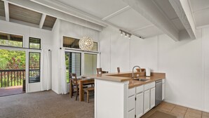 Una cocina moderna con armarios blancos, encimera de madera y lavavajillas integrado.