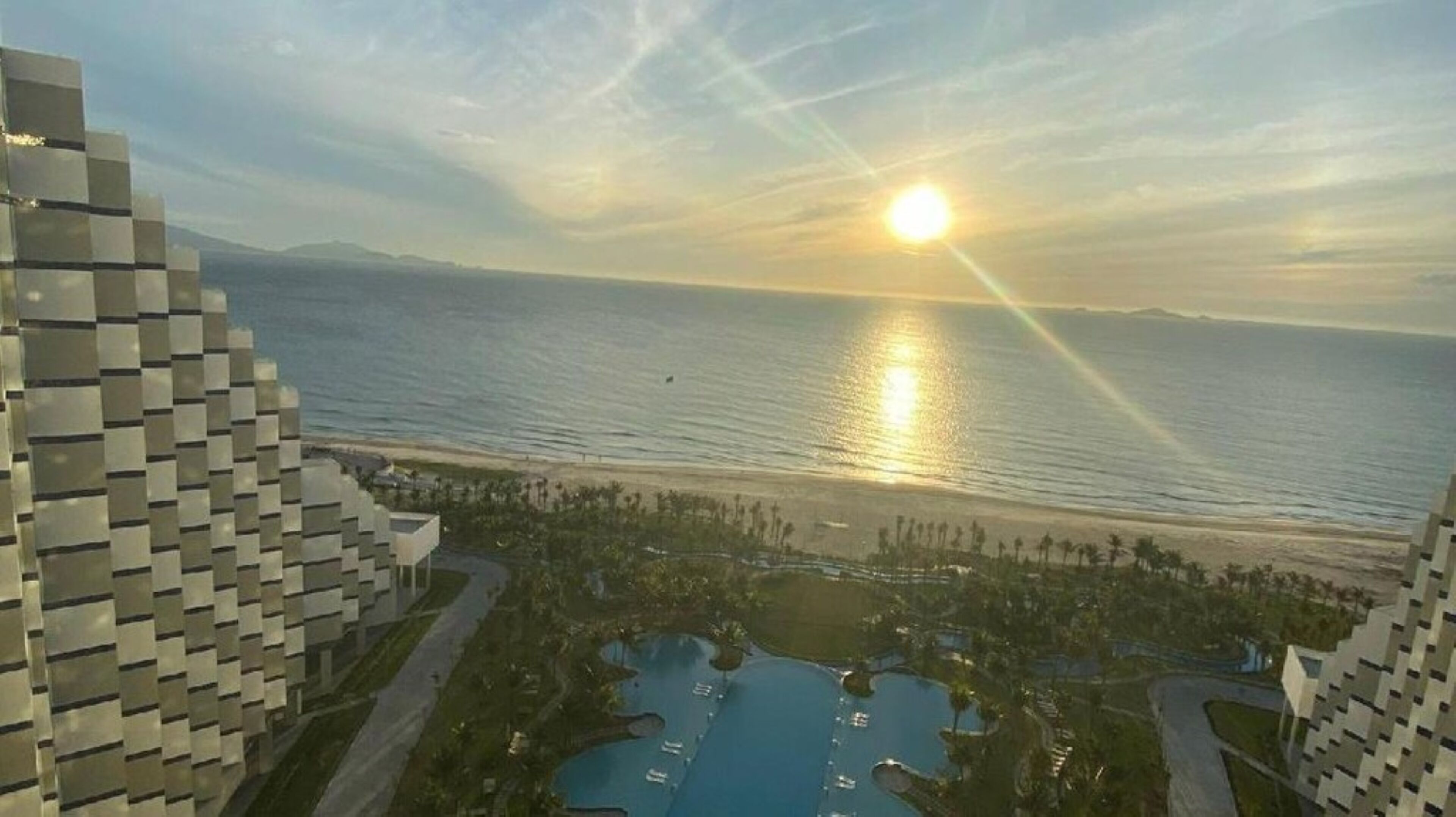 A coastal resort with modern architecture, a marina, and a large pool area.