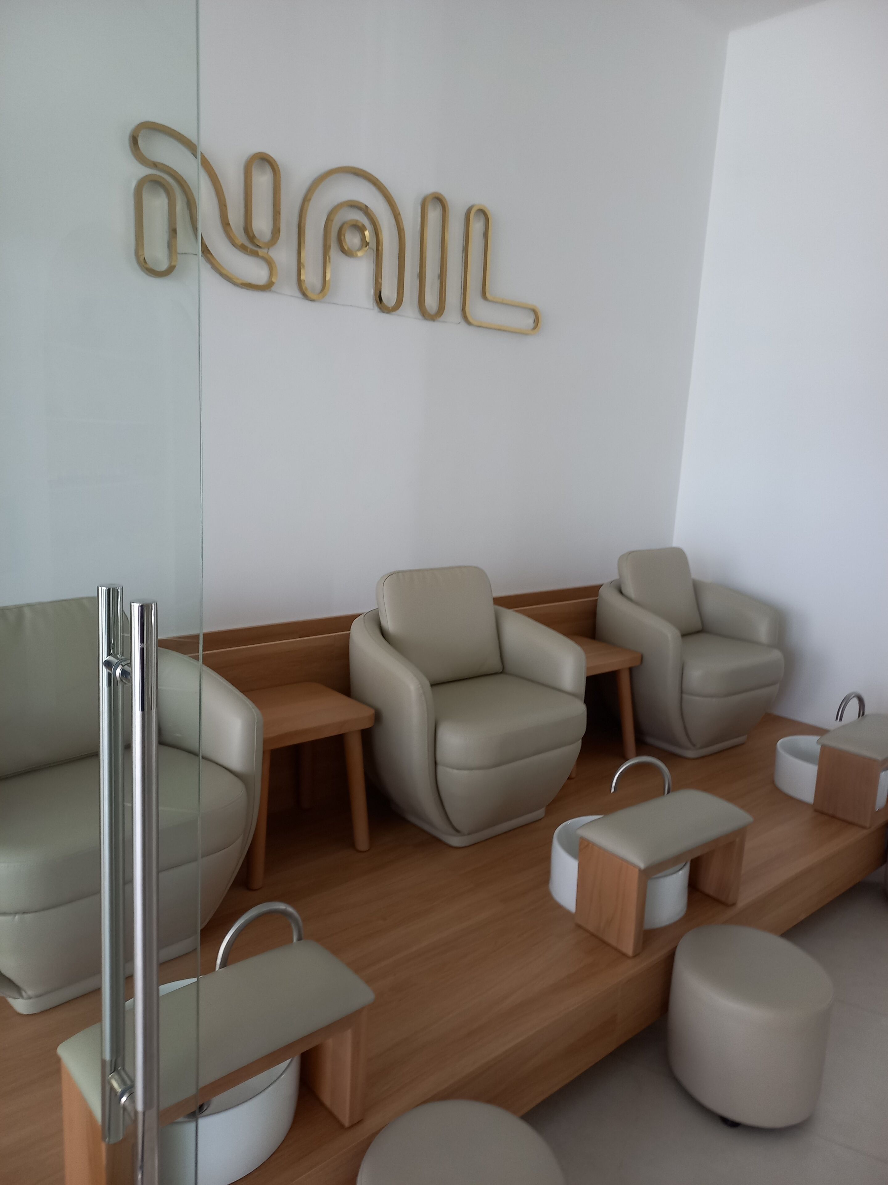 A modern waiting area with leather armchairs, a reception desk, and a wall-mounted sign.
