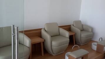 A modern waiting area with leather armchairs, a reception desk, and a wall-mounted sign.