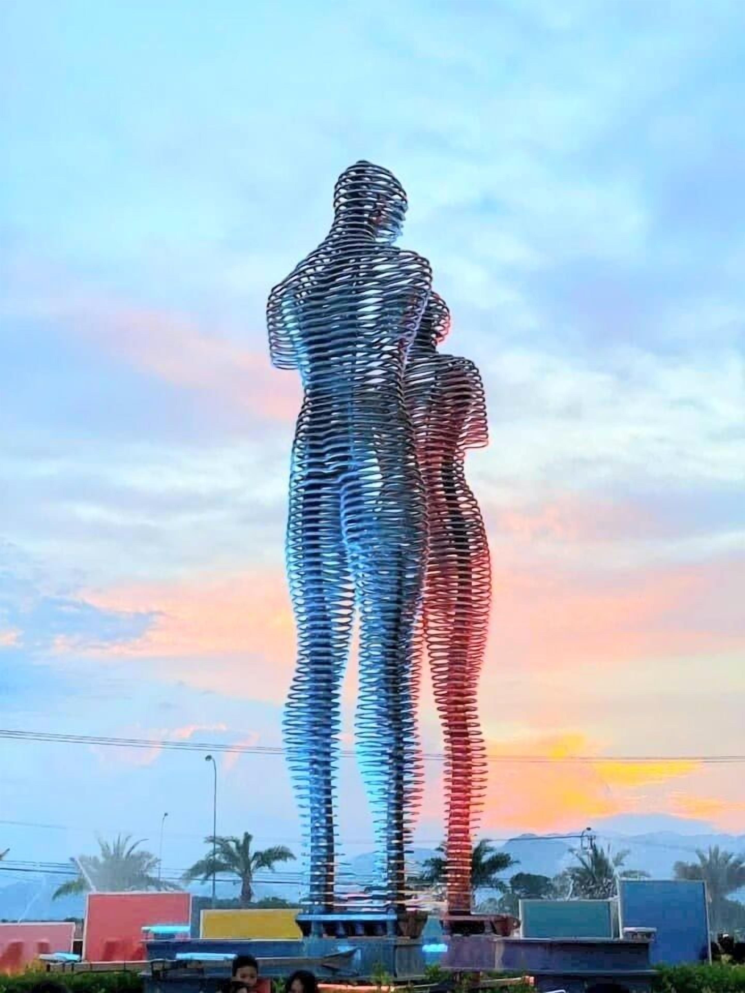 Une sculpture métallique représentant une figure humaine, installée dans un espace public.