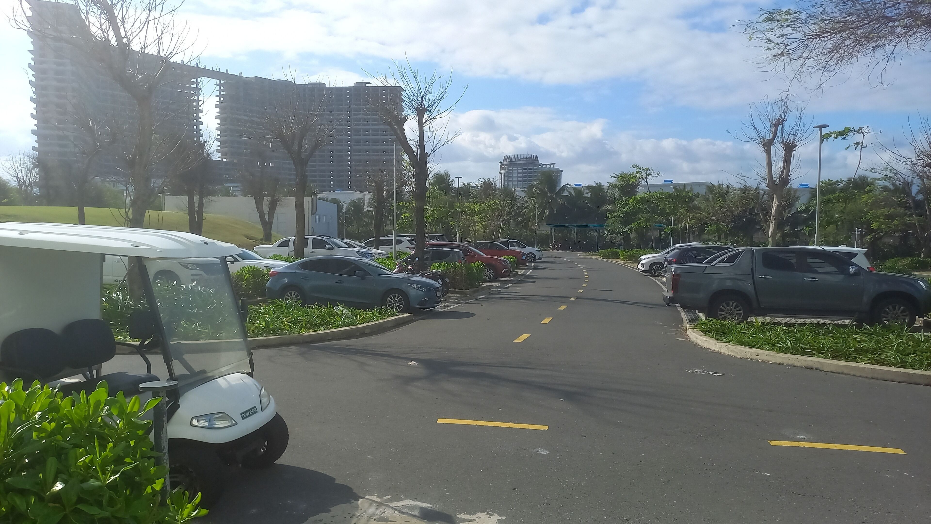 Un estacionamiento con varios coches y una furgoneta blanca.