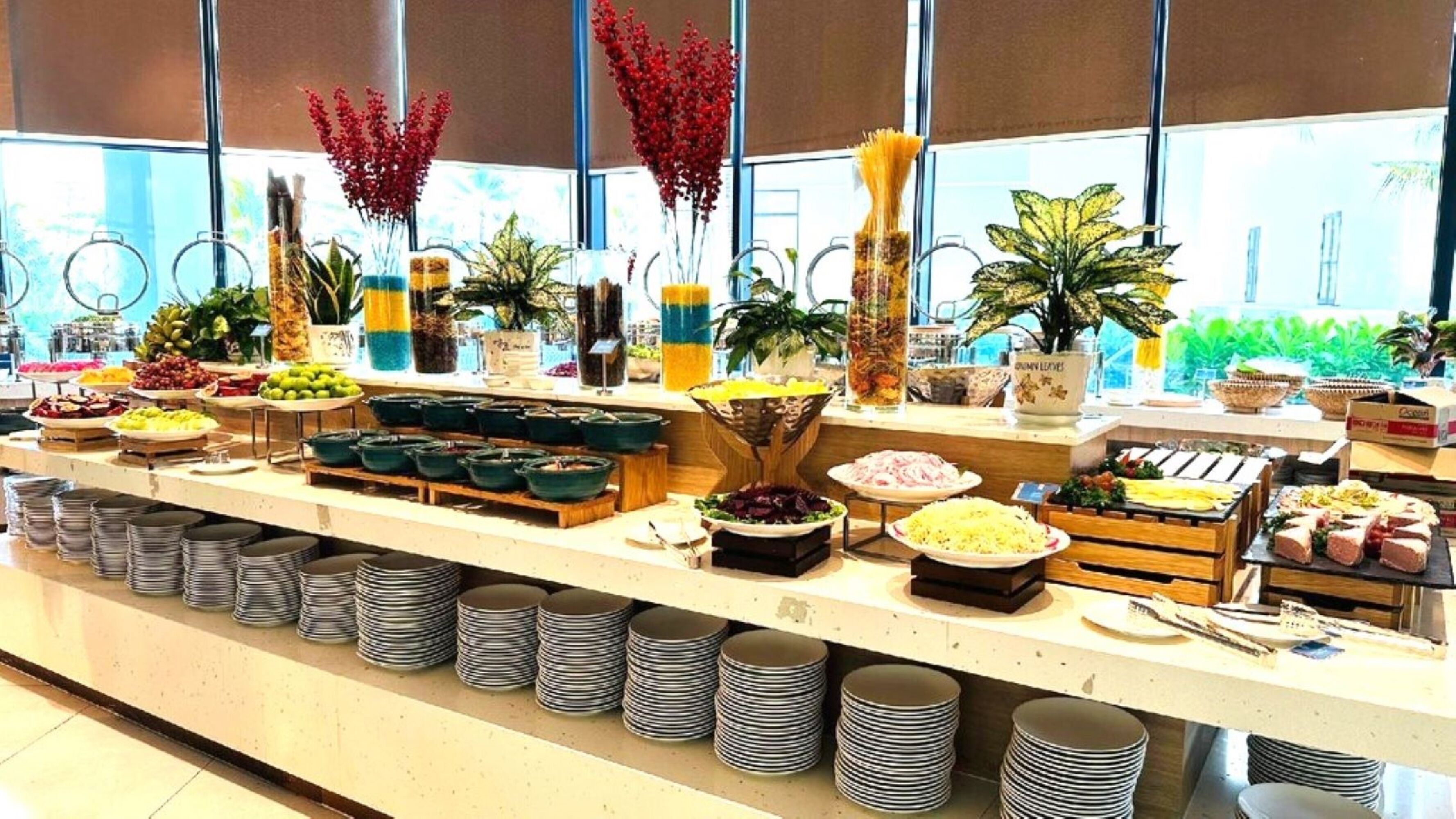 A buffet with various food items and a variety of fruits and vegetables.