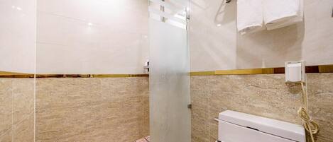 A bathroom with a shower, a toilet, and a towel rack.