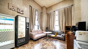 Une chambre d’hôtel équipée d’un minibar, d’un canapé, d’une petite table et d’une chaise.
