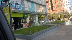 A modern building with multiple storefronts, including a Mr. Pizza and a Plexus store.