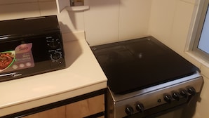 A kitchen with a stove, oven, and a white countertop.