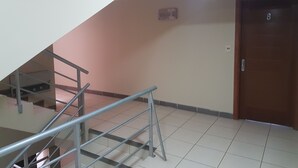 A staircase with metal railings leading to a landing. A door with the number 8 is visible to the right.