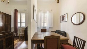 A dining area with a wooden table, chairs, and a chandelier.