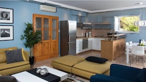 A compact living space with a kitchenette, a dining area, and a seating area with a sofa and a table.